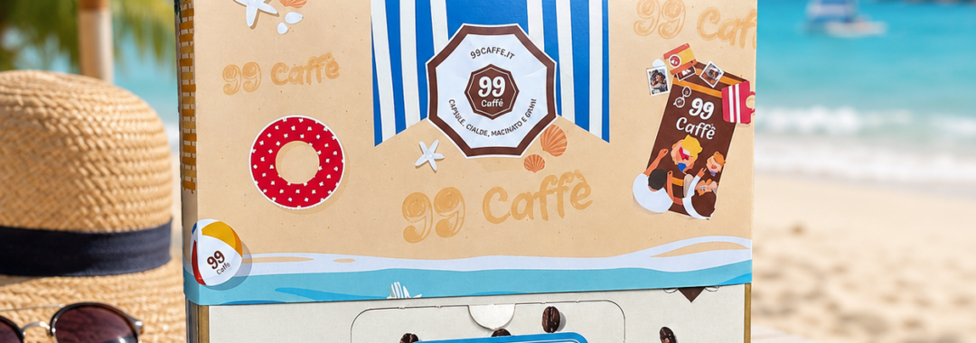 Confezione di cialde 99 Caffè Summer Edition su un tavolo in spiaggia, con ombrellone, mare e cappello di paglia