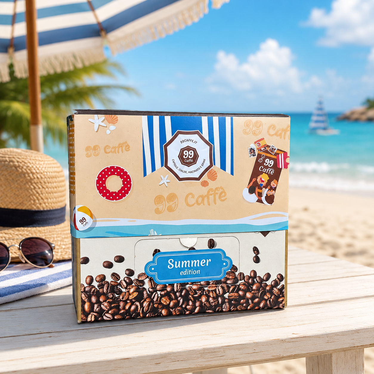 Confezione di cialde 99 Caffè Summer Edition su un tavolo in spiaggia, con ombrellone, mare e cappello di paglia